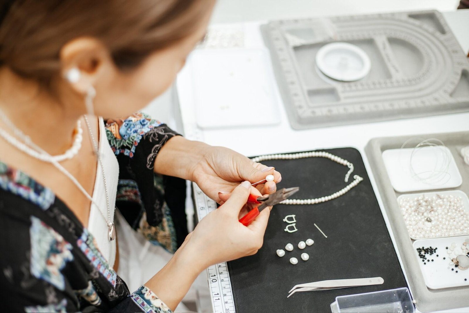 An Adiba Ayu artisan examining a pearl necklace